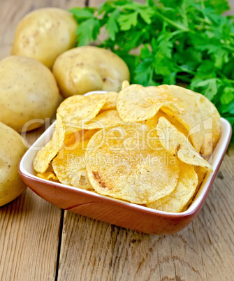 chips in a bowl with a potato on the board