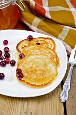 flapjacks with cranberry in a plate on a board