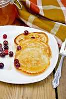 flapjacks with cranberry in a plate on a board