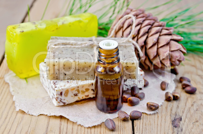 oil and soap different with cedar nuts and cone on a board