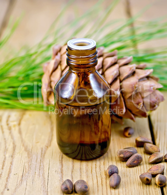 oil with cedar cone and nuts on the board