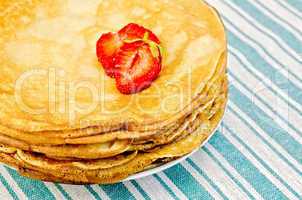 pancakes on a plate with strawberries on a napkin