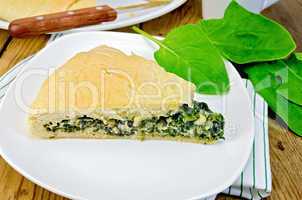 pie with spinach and cheese on the board with leaves