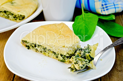 pie with spinach and cheese with a fork on a board