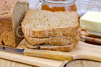 Rye homemade bread stacked with honey and knife