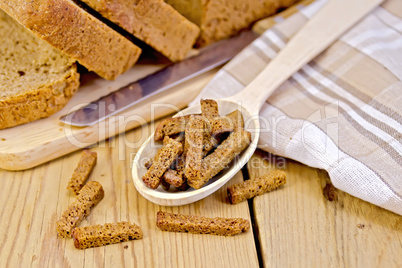 Rye homemade bread with croutons in spoon on a board