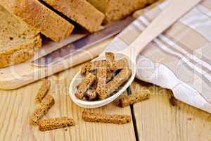 Rye homemade bread with croutons in spoon on a board