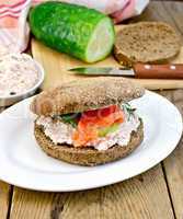 Sandwich with cream and salmon with cucumber on board