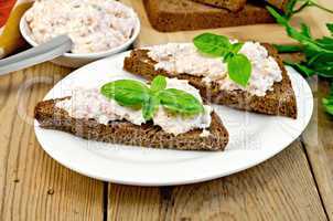 Sandwiches with cream of salmon with basil on board
