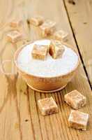 Sugar brown and white in a wooden bowl on a board