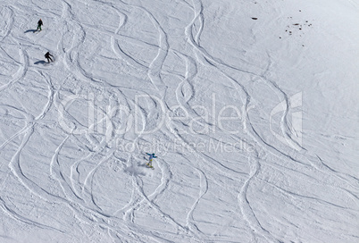 snowboarders and skiers downhill on off piste slope.