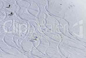 snowboarders and skiers downhill on off piste slope.