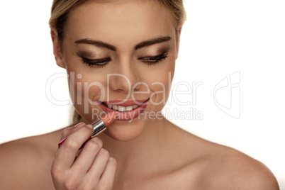beautiful young woman applying lipstick