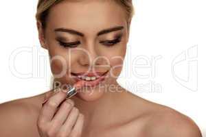 beautiful young woman applying lipstick