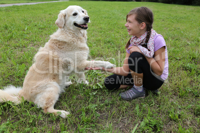 Hund gibt einem Mädchen die Pfote