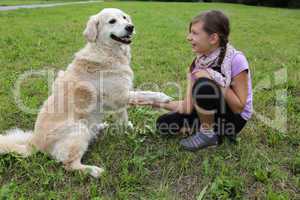 Hund gibt einem Mädchen die Pfote
