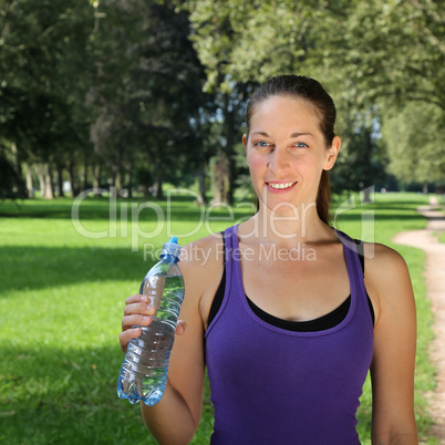 Sportliche Frau mit Wasserflasche beim Joggen oder Laufen