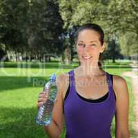 Sportliche Frau mit Wasserflasche beim Joggen oder Laufen