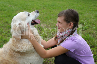 Mädchen schmust mit einem Hund