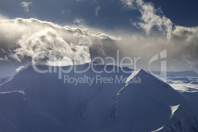 mountains in evening with sunlit clouds