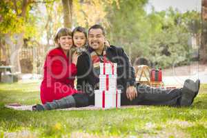 mixed race family enjoying valentine's gifts in the park together