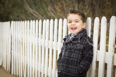 young mixed race boy waiting for schoold bus along fence