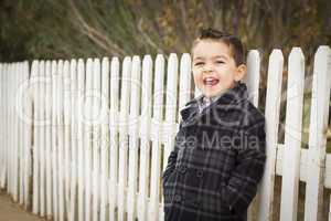 young mixed race boy waiting for schoold bus along fence