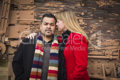 mixed race couple portrait in winter clothing against rustic tra