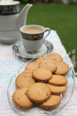 tray full of biscuits served with tea pot and a cup