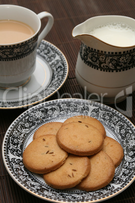 plate full of biscuits served with milk pot and a cup of tea