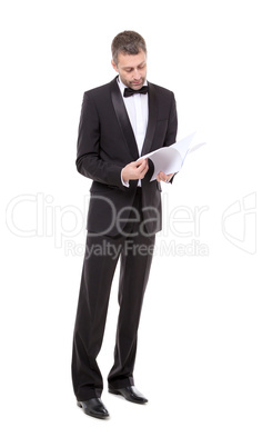 man in a tuxedo reading the document