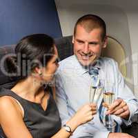 flight cabin business partners toasting champagne