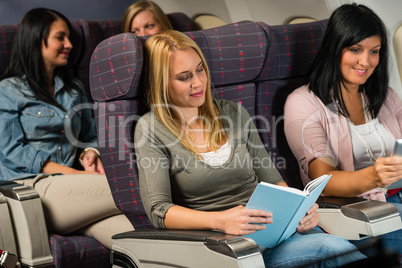 young woman passenger read book airplane flight