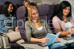 young woman passenger read book airplane flight