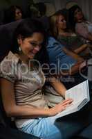 young woman read book plane night flight
