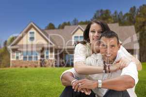 happy hispanic young couple in front of their new home