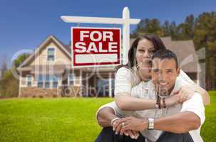hispanic couple, new home and for sale real estate sign