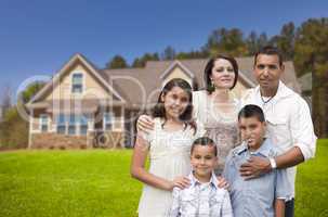 young hispanic family in front of their new home