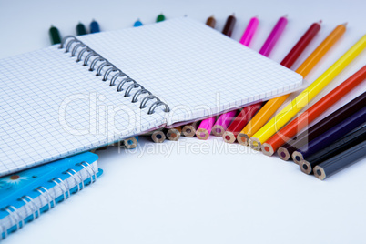 a stack of colored pencils with notebook