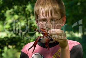 kind mit einem flußkrebs in der hand