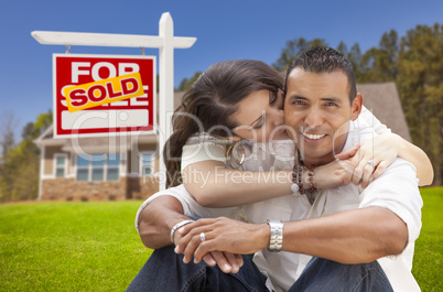 hispanic couple, new home and sold real estate sign