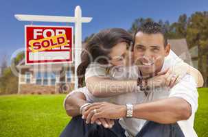hispanic couple, new home and sold real estate sign