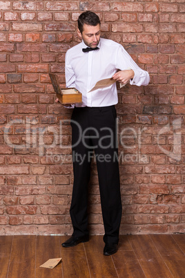 man reading a document from a wooden box