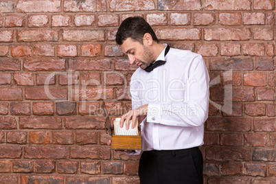 man reading a document from a wooden box