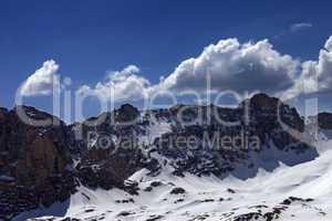snowy rocks and blue sky with cloud in sunny spring day