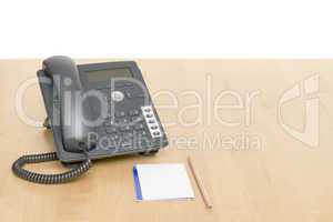 phone on desk with notepad on wooden desk