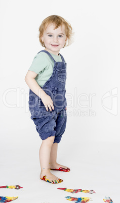 child with painted feet holding trousers