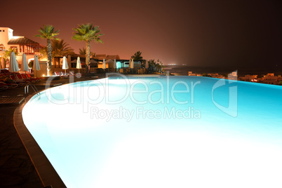 the swimming pool at luxury hotel in night illumination, ras al