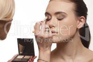 beautician applying eye makeup