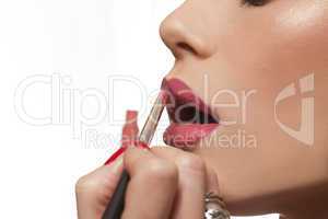 young woman applying lipstick